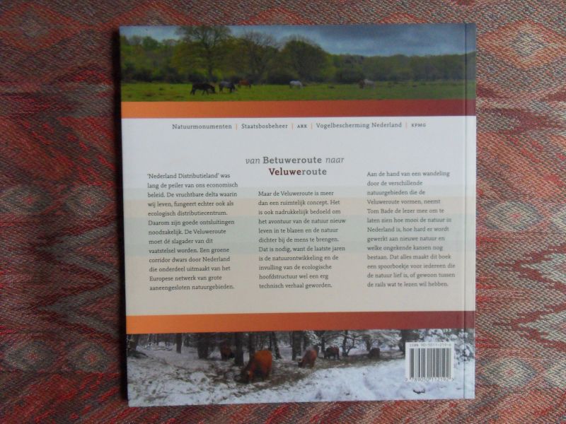 Bade, Tom. - Van Betuweroute naar Veluweroute. - De Nederlandse natuurontwikkeling op de rails. --- 1e druk, 2005. Paperback. In nieuwstaat. Geen naam ingeschreven en geen onderstrepingen. 48 pp. Met prachtige natuurfoto`s van Ruud Lardinois.