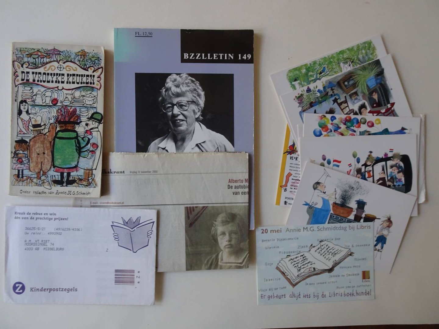 Schmidt, Annie M.G.. - De vrolyke keuken (onder redactie van Annie M.G. Schmidt)/ Een krantenartikel van 8 november 2002 uit de Volkskrant "Altijd iedereen behagen"/ Een kaart t.g.v. de Annie M.G. Schmidtdag bij Libris, op 20 mei/ Een setje Kinderpostzegels met ontw...