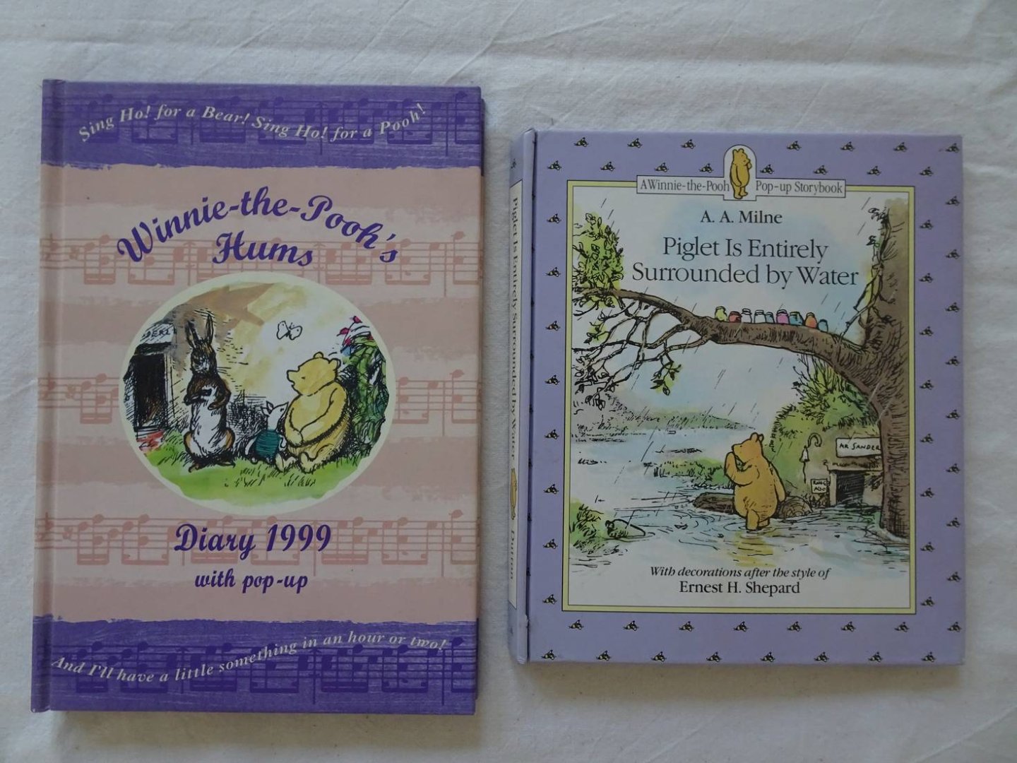 Milne, A.A. & Ernest Shepard. - Piglet is entirely surrounded by water. A Winnie-the-Pooh pop-up Storybook/ Winnie-the-Pooh's hums. Diary 1999, with pop-up. 2 titles.