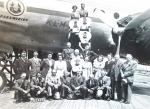  - (Naoorlogse) Zwart-wit foto van een groep inwoners uit Kapelle en Biezelinge, deels in Bevelandse klederdracht, genomen op Schiphol voor en op een propeller-vliegtuig(-trap)